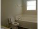Bright bathroom features a toilet, vanity, and a large bathtub at 214 Oak Cir, Stockbridge, GA 30281