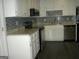 Kitchen featuring granite countertops, stainless steel appliances, white cabinets and tiled backsplash at 214 Oak Cir, Stockbridge, GA 30281