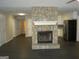 Spacious living room with a stone fireplace and dark modern flooring, open to the kitchen at 214 Oak Cir, Stockbridge, GA 30281
