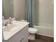 Well-lit bathroom featuring a modern single vanity, a toilet, and a shower tub at 6398 Lanier Harbor Lndg, Buford, GA 30518