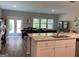 Open concept kitchen features granite countertops, stainless sink and views into the living and dining spaces at 6398 Lanier Harbor Lndg, Buford, GA 30518