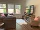 Spacious living room boasts a fireplace and backyard views through large windows for ample natural light at 6398 Lanier Harbor Lndg, Buford, GA 30518