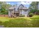 Exterior of the home features a spacious backyard, patio, a deck, complemented by mature trees and landscaping at 68 Timber Creek Estates Dr, Sharpsburg, GA 30277