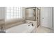 Luxurious bathroom with a soaking tub, frameless shower, and neutral tile at 68 Timber Creek Estates Dr, Sharpsburg, GA 30277