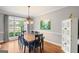 Bright dining room features a wooden table, black chairs, and a large window with checkered curtains at 68 Timber Creek Estates Dr, Sharpsburg, GA 30277