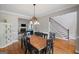 Inviting dining room featuring hardwood floors, a large wooden table, and a view into the living room and foyer at 68 Timber Creek Estates Dr, Sharpsburg, GA 30277