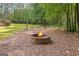 Backyard fire pit with a circular stone border, swing set, offering a serene outdoor gathering spot at 68 Timber Creek Estates Dr, Sharpsburg, GA 30277