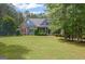 Charming blue two-story home featuring stone accents and a lush, well-manicured lawn surrounded by mature trees at 68 Timber Creek Estates Dr, Sharpsburg, GA 30277
