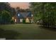 Charming blue two-story home featuring stone accents and a lush, well-manicured lawn surrounded by mature trees at twilight at 68 Timber Creek Estates Dr, Sharpsburg, GA 30277
