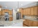 Well-equipped kitchen featuring granite countertops, stainless steel appliances, and wood cabinets at 68 Timber Creek Estates Dr, Sharpsburg, GA 30277