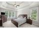 Spacious main bedroom with a tray ceiling, ceiling fan, and windows providing natural light at 68 Timber Creek Estates Dr, Sharpsburg, GA 30277