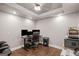 A home office with hardwood floors, multiple screens, ceiling fan, and neutral gray-painted walls at 68 Timber Creek Estates Dr, Sharpsburg, GA 30277