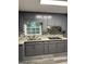 Kitchen features gray cabinets, granite countertops, stainless steel appliances, and decorative tile backsplash at 554 Windsor Dr, Forest Park, GA 30297