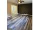 Open-concept living room boasts stylish gray floors and a decorative accent wall with geometric designs at 554 Windsor Dr, Forest Park, GA 30297