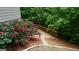 Manicured backyard featuring a stone path, wood railing, and garden with red roses at 5760 Winding Lakes Dr, Cumming, GA 30028