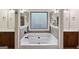 Serene bathroom featuring dual vanities, a deep soaking tub, and decorative accents at 5760 Winding Lakes Dr, Cumming, GA 30028