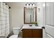 Bathroom featuring a wood vanity, a framed mirror, modern lighting, and a shower-tub combo at 5760 Winding Lakes Dr, Cumming, GA 30028