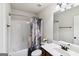 Bathroom with stylish shower curtain, white tub, and vanity with a marble countertop and dark wood cabinets at 5760 Winding Lakes Dr, Cumming, GA 30028