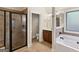 Well-lit bathroom showcasing a modern glass shower, soaking tub, and dark wood vanity at 5760 Winding Lakes Dr, Cumming, GA 30028