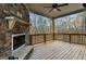 Covered deck featuring a stone fireplace and wooded views at 5760 Winding Lakes Dr, Cumming, GA 30028
