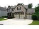 Beautiful brick home with a three-car garage and lush landscaping at 5760 Winding Lakes Dr, Cumming, GA 30028