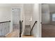 Hallway with hardwood floors, decorative iron railing, and view of downstairs at 5760 Winding Lakes Dr, Cumming, GA 30028