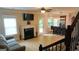 Open living room with hardwood floors, fireplace, windows, and access to an adjacent kitchen at 5760 Winding Lakes Dr, Cumming, GA 30028