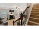 Bright living room with fireplace and stairs featuring decorative wood and iron banister at 5760 Winding Lakes Dr, Cumming, GA 30028