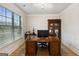 Bright office with a large window, wooden desk, built-in bookshelf and hardwood floors at 5760 Winding Lakes Dr, Cumming, GA 30028