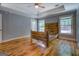 Spacious bedroom featuring a rustic wood bed frame, hardwood floors, and tray ceiling at 4979 Snook Thompson Se Rd, Oxford, GA 30054