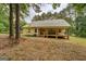 Exterior view of house featuring a covered porch and trees in the backyard at 4979 Snook Thompson Se Rd, Oxford, GA 30054