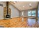 Bright living room featuring hardwood floors, fireplace, and a large window for natural light at 4979 Snook Thompson Se Rd, Oxford, GA 30054