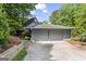 Exterior shot of home with attached garage and lush surrounding greenery at 3863 Dundee Ne Dr, Roswell, GA 30075