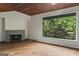 Cozy living room featuring a fireplace and scenic views of the surrounding nature at 3863 Dundee Ne Dr, Roswell, GA 30075