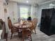 Cozy dining area with a wooden table, four chairs, built in white cabinets, and a black refrigerator at 3969 W Hilda Cir, Decatur, GA 30035