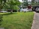 Charming front yard featuring a well-maintained lawn and a white painted brick home with blue door and mature landscaping at 3969 W Hilda Cir, Decatur, GA 30035