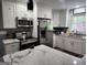 Modern kitchen with stainless steel appliances, marble countertops, sleek white cabinets, and stylish gray backsplash at 3969 W Hilda Cir, Decatur, GA 30035
