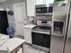 Modern kitchen featuring stainless steel appliances, white cabinets, sleek countertops, and a contemporary tile backsplash at 3969 W Hilda Cir, Decatur, GA 30035