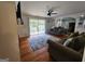 Hardwood floors and a stone fireplace highlight a comfortable living room with a ceiling fan and sliding glass doors to the yard at 3969 W Hilda Cir, Decatur, GA 30035