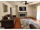 Inviting living room features hardwood floors, a decorative fireplace, a comfortable sofa, and a modern ceiling fan at 3969 W Hilda Cir, Decatur, GA 30035