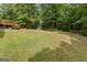 A lush green lawn leads from the deck and grill area to a wooded area in the spacious backyard at 372 River Point Dr, Mcdonough, GA 30252