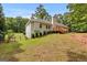 A fenced yard with a lush lawn surrounds this home, with a deck and stairs leading up to the house at 372 River Point Dr, Mcdonough, GA 30252