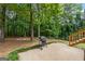Backyard view featuring a grill and a lush green lawn leading to a wooded area at 372 River Point Dr, Mcdonough, GA 30252