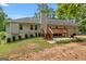 Exterior view of the home showcasing a spacious backyard, a deck, and mature landscaping at 372 River Point Dr, Mcdonough, GA 30252