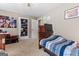 Comfortable bedroom with wood floors, built in dresser with TV and a blue striped bedspread at 372 River Point Dr, Mcdonough, GA 30252