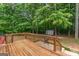 A wooden deck with a grill and stairs leading to a lush, green backyard with a storage shed at 372 River Point Dr, Mcdonough, GA 30252