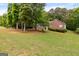 Home featuring a well-manicured front lawn and mature trees, offering shade and curb appeal at 372 River Point Dr, Mcdonough, GA 30252