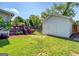 A backyard with a small deck, storage shed, fire pit, and a swing set, surrounded by green grass at 5327 David Se Cir, Covington, GA 30014