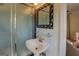 Cozy bathroom features a pedestal sink, framed mirror, glass shelf, and walk-in shower at 5327 David Se Cir, Covington, GA 30014