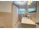 Traditional bathroom featuring tan tiling, a shower-tub combo, and single sink vanity at 5327 David Se Cir, Covington, GA 30014
